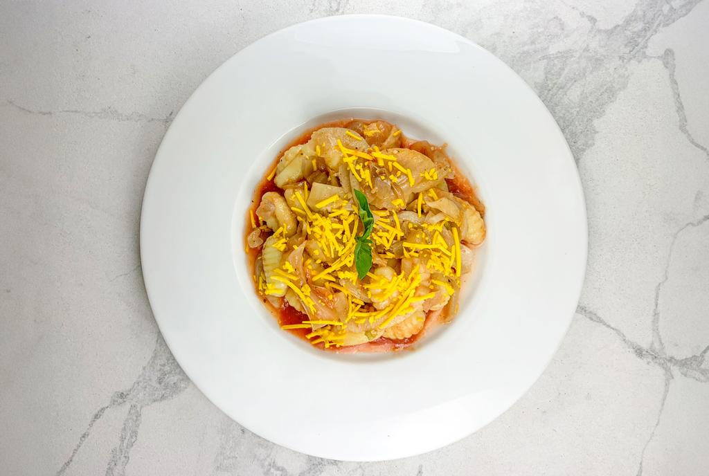 Gnocchi, tomatensaus, gegrilde venkel en sjalotten, vegan cheddar. 