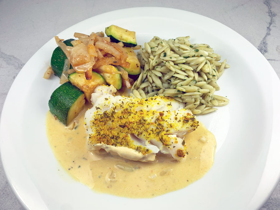 Filet d’aiglefin au curcuma, sauce jaune au lait de coco, courgettes et oignons rôtis au four, pâtes orzo au basilic